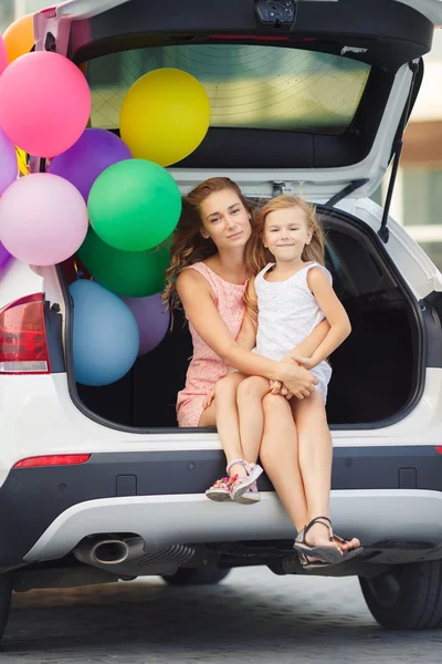 Mãe e filha em um carro com balões — Fotografia de Stock