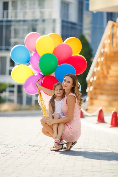 Мать и ребенок с цветными воздушными шарами — стоковое фото