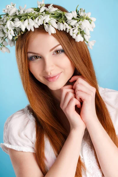 Studio portret van een meisje in een krans van bloemen — Stockfoto