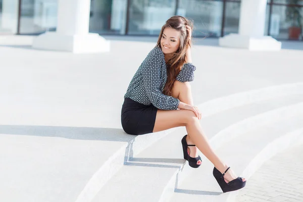 Portrait of a beautiful young woman, sitting on the stairs in the city. — Stock Photo, Image