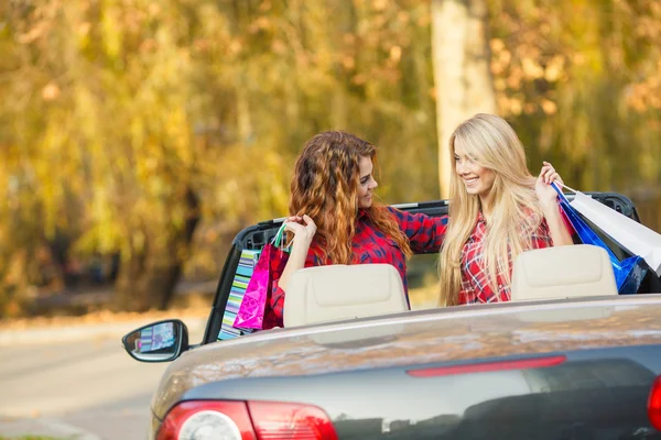 Girls with shopping bags in the convertible. — Stockfoto
