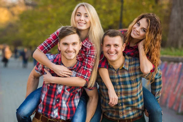 Dos parejas jóvenes pasan tiempo en el parque a principios de otoño — Foto de Stock