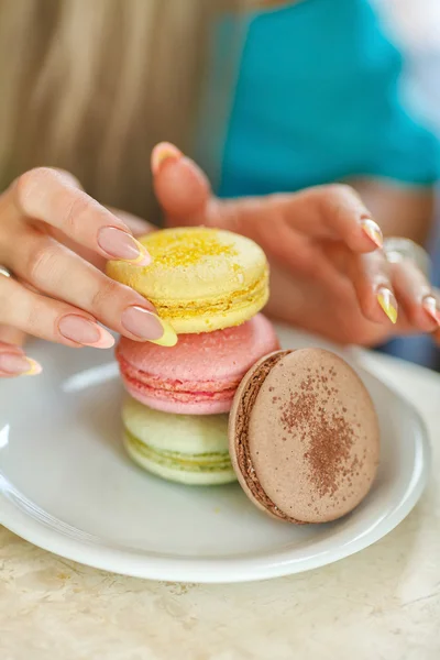 Hands of young woman and macaroons — 图库照片