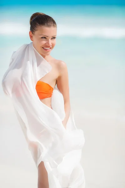 Mooie vrouw aan het strand in oranje bikini — Stockfoto