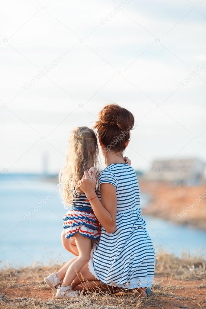 Mother and his adorable little daughter at beach