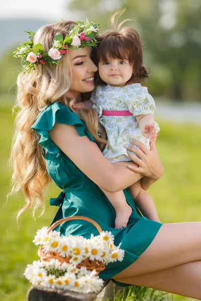 Happy mother with little daughter on the green meadow — Stok fotoğraf