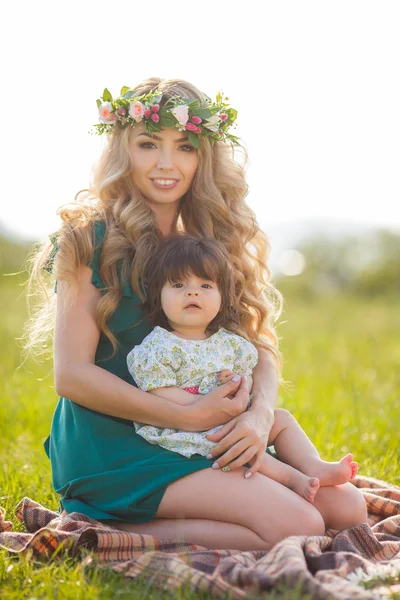 Счастливая мать с маленькой дочерью на зеленом лугу — стоковое фото