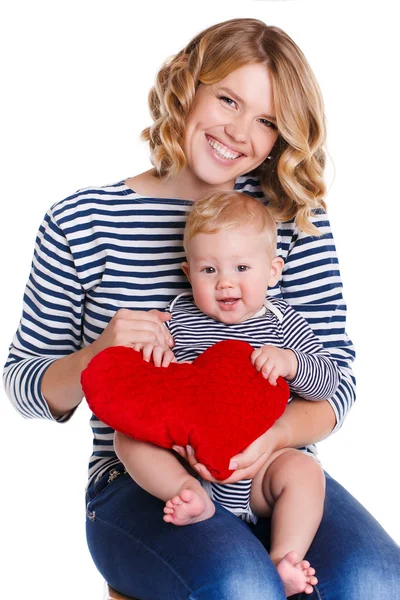 Happy mother and her little son holding a pillow in the form of red hearts. — Stok fotoğraf