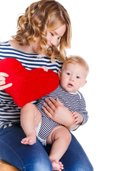 Mãe feliz e seu filho segurando um travesseiro na forma de corações vermelhos . — Fotografia de Stock