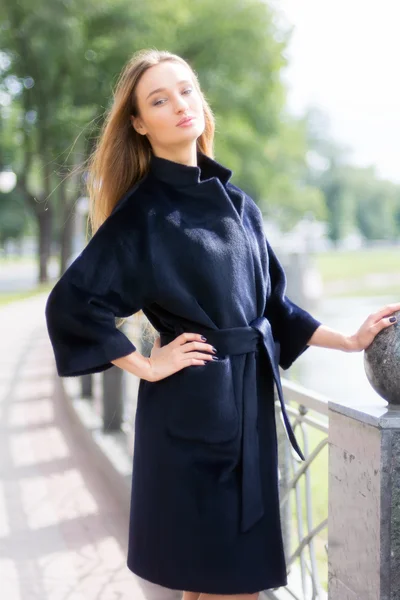 Mooie bruinharige vrouw in een zwarte jas — Stockfoto