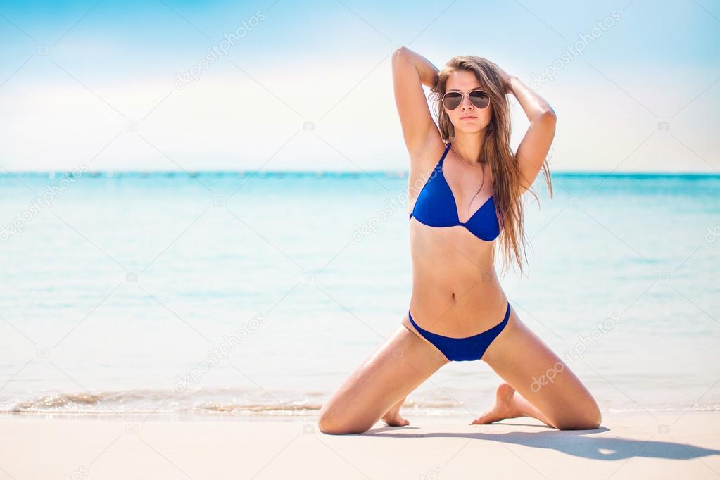 Portrait of woman in black swim posing on tropical beach