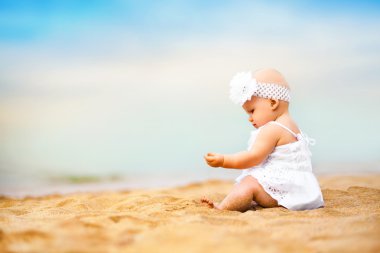 Kumsalda oynarken küçük şirin bebek kız