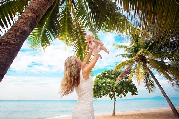 Jonge moeder en schattige baby spelen op tropisch strand — Stockfoto