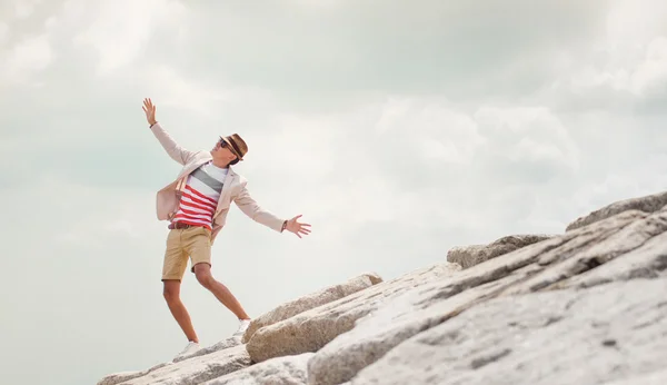在岩石上，跳舞的年轻男士感到自由，蓝色天空背景. — 图库照片