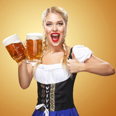 Büyük bira bardağı mavi zemin üzerine hizmet veren bir geleneksel Bavyera elbise giyen genç seksi Oktoberfest garson. Thumbsup