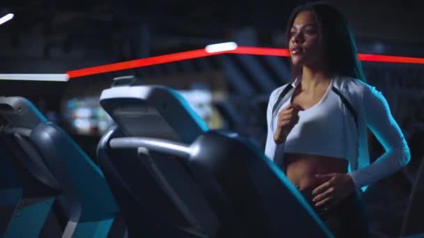 Gadis hitam berjalan di atas treadmill. Wanita cantik berjalan di gym. Gerakan lambat. — Stok Video