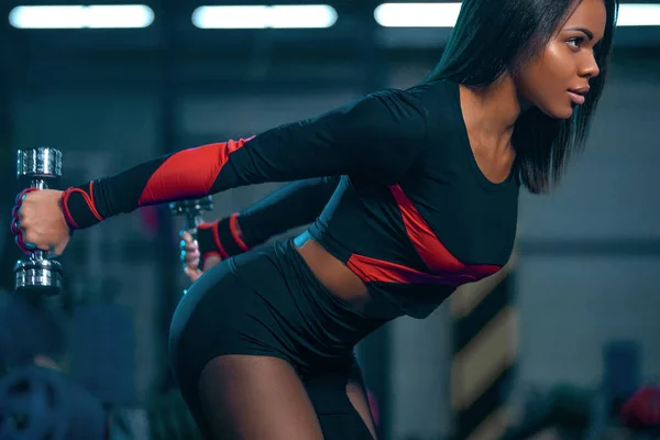 Izmos fiatal fitness sportok nő edzés súlyzók fitness tornaterem. — Stock Fotó