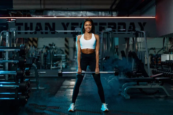 Spor salonundaki halterle spor yapan kaslı genç bir kadın.. — Stok fotoğraf