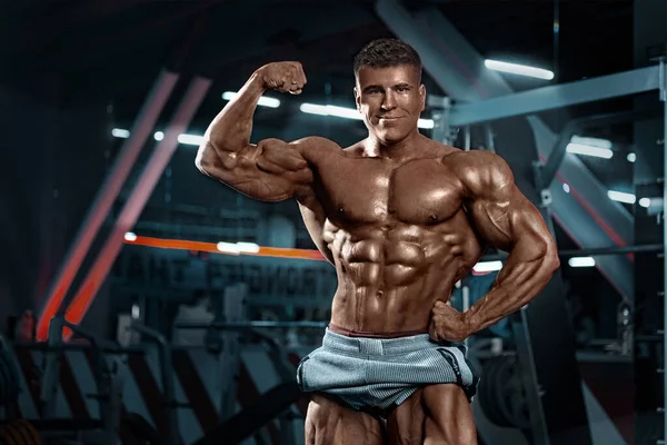 Bodybuilder athlète homme pompage les muscles dans la salle de gym. Brutal musclé fort gars sur la séance d'entraînement de remise en forme. Concept de bodybuilding. — Photo