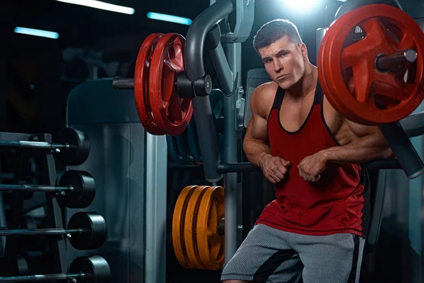 Atleta culturista uomo pompaggio muscoli in palestra. Brutale ragazzo muscoloso forte in allenamento fitness. Concetto di culturismo. — Foto Stock