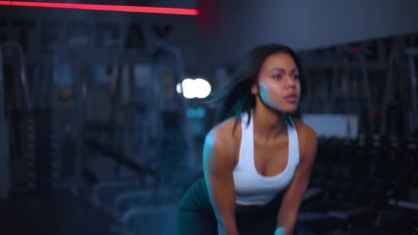 Тренажерний зал та фітнес-концепція. М'язиста молода спортивна жінка тренується з гантелями у фітнес-спортивному клубі . — стокове відео