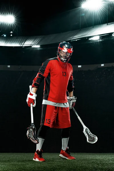 Lakros hráč, sportovec v červené helmě na pozadí stadionu. Sportovní a motivační tapety. — Stock fotografie