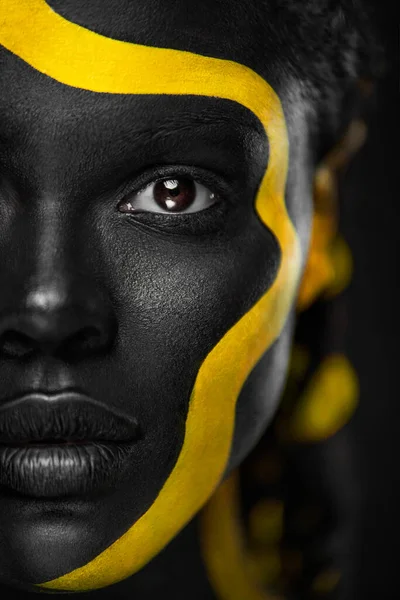 Yellow and black body paint. Woman with face art. Young girl with colorful bodypaint. An amazing afro american model with makeup. — Stock Photo, Image