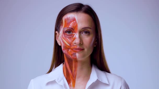 Junge Frau mit halbem Gesicht und Muskelstruktur unter der Haut. Modell für die medizinische Ausbildung auf hellem Hintergrund. Nahaufnahme Video von Gesicht menschliche Anantomie. — Stockvideo