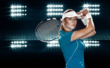 Mavi kostümlü bir tenisçi. Büyük arenada oynayan kadın sporcu.