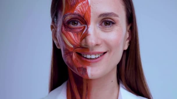 Jonge vrouw met half gezicht met spierstructuur onder de huid. Model voor medische training op een lichte achtergrond. close-up video van gezicht menselijke anantomie. — Stockvideo