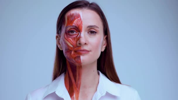 Botox-Injektion ins Gesicht. Junge Frau mit halbem Gesicht und Muskelstruktur unter der Haut. Modell für die medizinische Ausbildung auf hellem Hintergrund. Nahaufnahme Video von Gesicht menschliche Anantomie. — Stockvideo