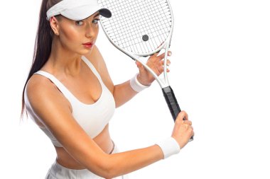 Beyaz kostümlü bir tenisçi. Beyaz arka planda tek başına oynayan kadın sporcu.