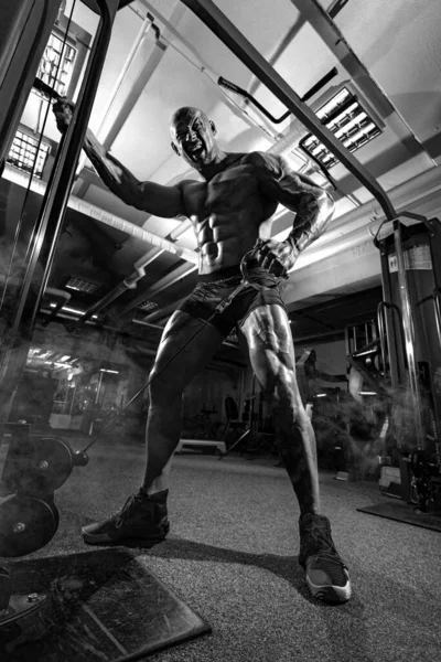 Vücut geliştirme sporcusu spor salonunda antrenman yapıyor. Antrenman aleti olan kaslı bir adam. Spor ve spor motivasyonu. Vücut geliştirme ile bireysel spor eğlencesi. — Stok fotoğraf