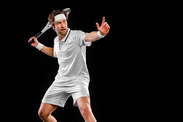 Jugador de tenis con raqueta en traje blanco. Hombre atleta jugando aislado sobre fondo negro. — Foto de Stock