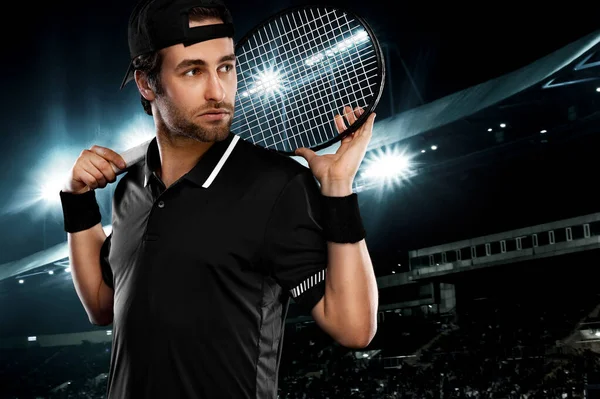 Tennis player with racket in black t-shirt. Man athlete playing on grand arena with tennis courts. — Stock Photo, Image