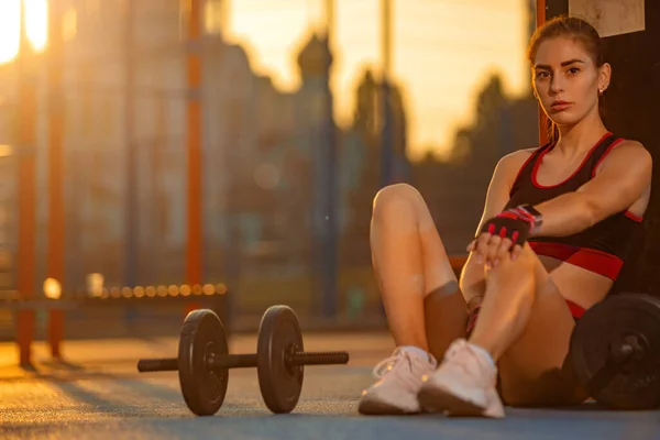 Atleta ragazza si allena con manubri sul campo sportivo sulla strada. Fitness all'aperto. Stile di vita conept. — Foto Stock