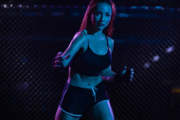 Boxen. Sportkonzept. Kämpferin im Kampf ohne Regeln in einem Käfig Oktobox. Neon Foto — Stockfoto