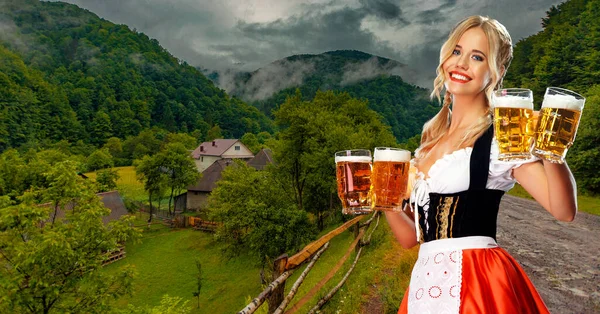 Oktoberfest lány pincérnő sörrel. Nő visel hagyományos bajor vagy német dirndl október fesztiválon, felszolgáló nagy bögrék itallal a hegyekben háttér. — Stock Fotó