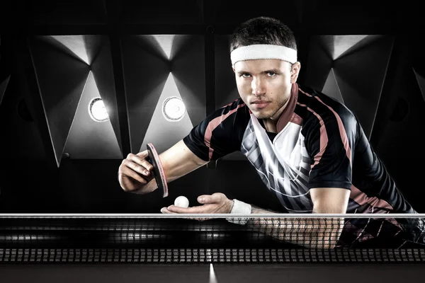 Young sport man tennis-speler in het spel op zwarte achtergrond — Stockfoto