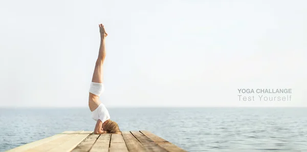 Beautiful positiveblond girl practicing yoga at seashore and meditating — Stock Photo, Image