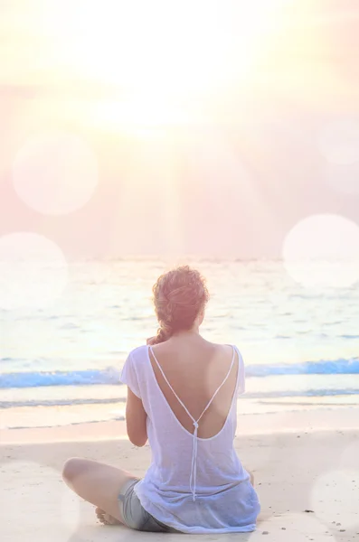 Vrouw het beoefenen van yoga bij sunrise beach — Stockfoto