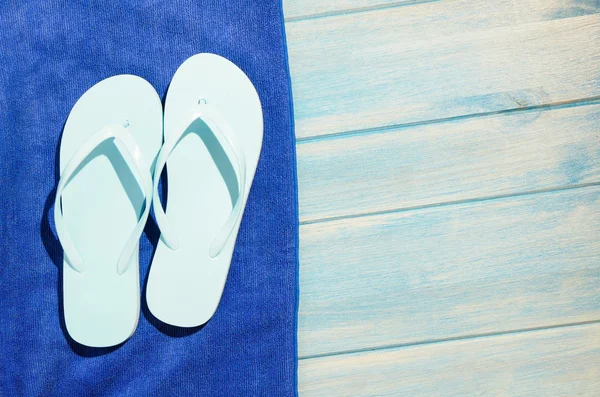 Flip-flops och handduk på bordet — Stockfoto