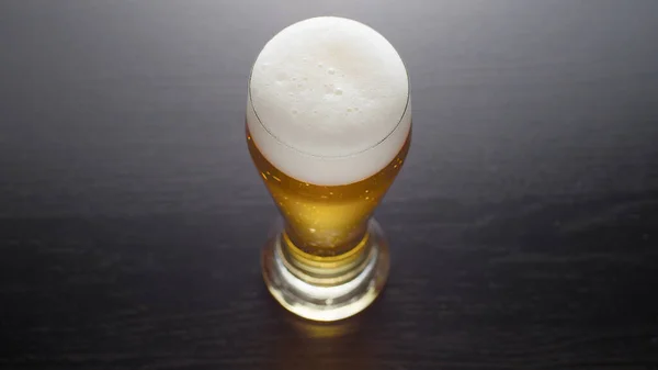 桌上放着一杯发泡的新鲜啤酒 — 图库照片