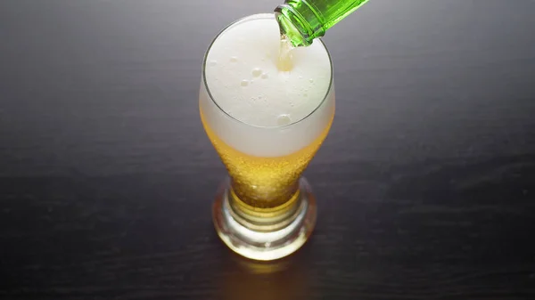 Verre de bière fraîche mousseuse sur la table — Photo