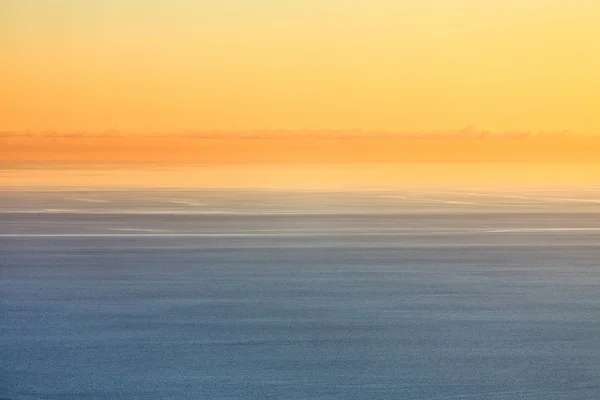 Orangefarbener Sonnenuntergang Himmel über blauem Meer — Stockfoto