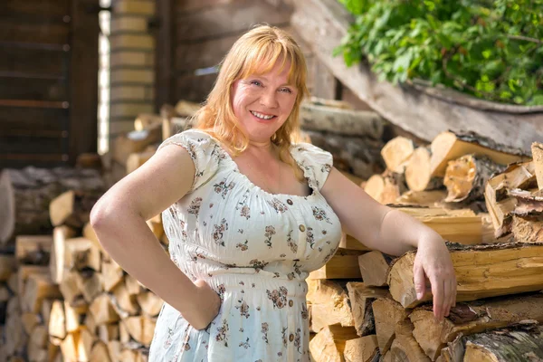 Retrato de una mujer cerca de la pila de madera —  Fotos de Stock