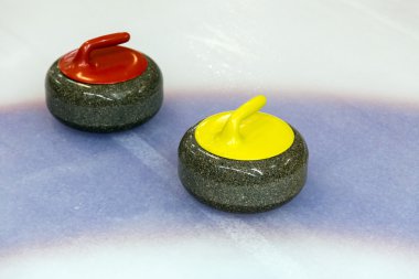Buz üstünde iki curling taşı