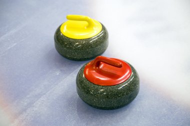 Buz üstünde iki curling taşı