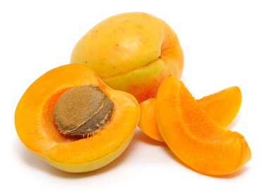 Beyaz arka planda izole edilmiş kayısı ve sulu portakal dilimleri. Vitamin açısından zengin olgun meyve parçaları. Taze organik kayısı hasat konsepti