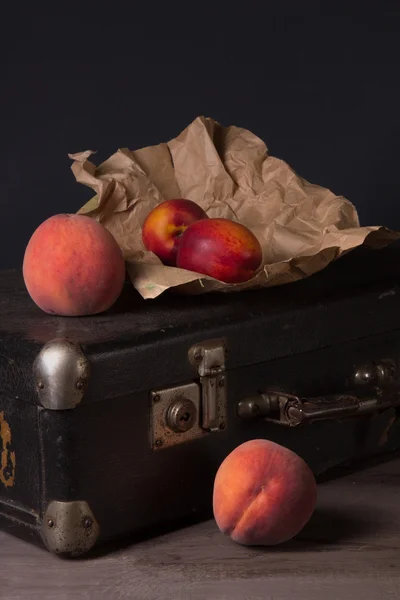 Nature morte avec un paquet et Pêches — Photo